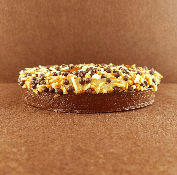 Tarta Ópera cuadrada vista de frente, mostrando claramente las capas alternas de bizcocho de almendra, crema de café y ganache de chocolate, con granos de café decorando la parte superior.