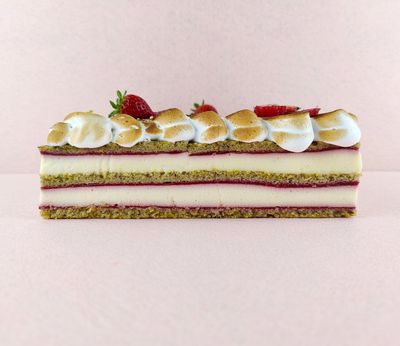 Tarta Ópera cuadrada vista de frente, mostrando claramente las capas alternas de bizcocho de almendra, crema de café y ganache de chocolate, con granos de café decorando la parte superior.