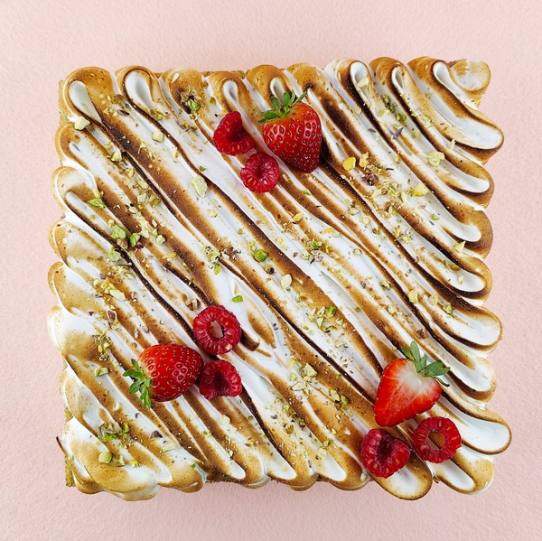 Primer plano de una Tarta Ópera cuadrada, resaltando la textura del glaseado chocolate, la suavidad de la crema de café, la cremosidad de la ganaché de chocolate y la esponjosidad del bizcocho gioconda empapado en café.
