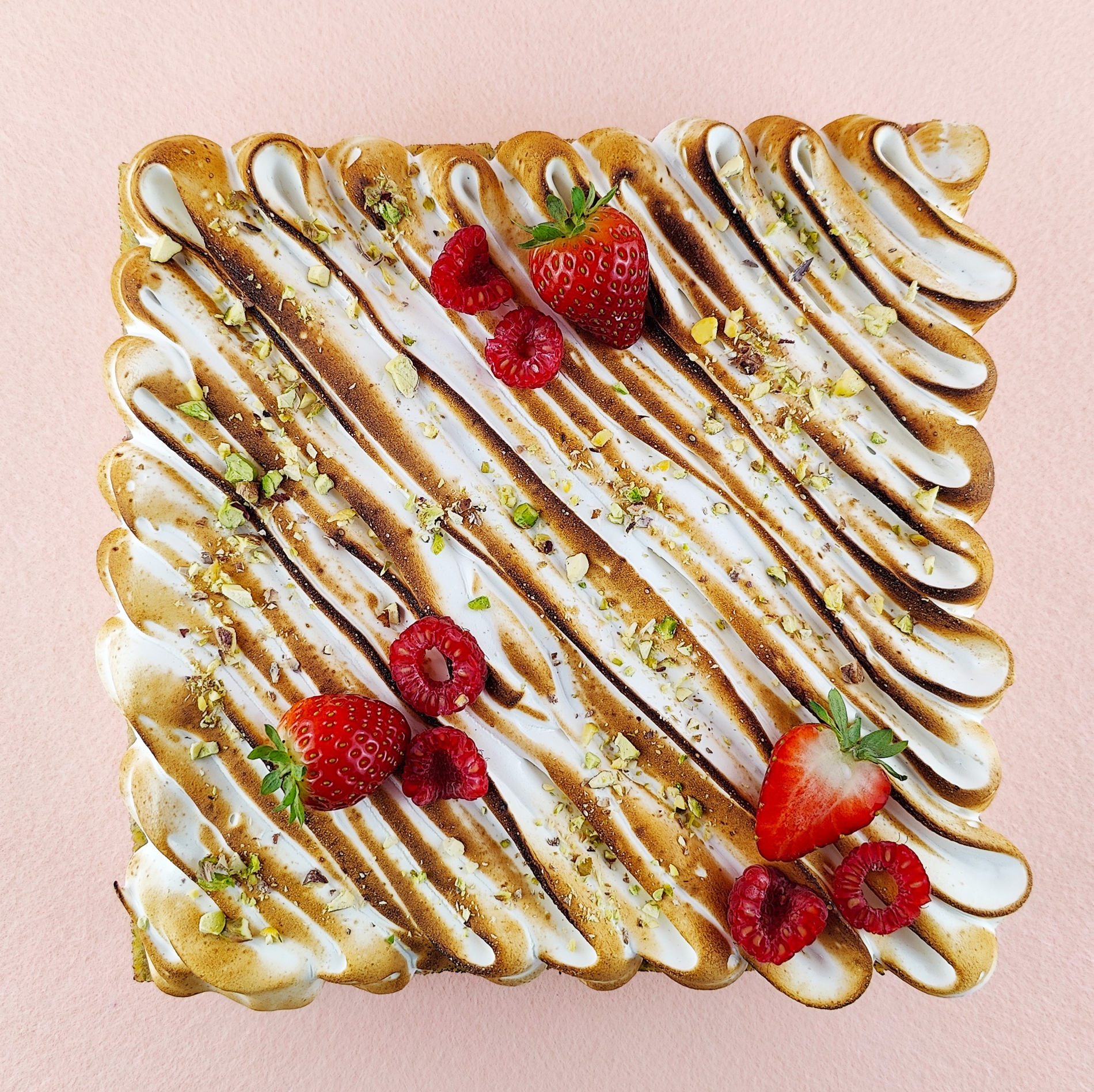 Primer plano de una Tarta Ópera cuadrada, resaltando la textura del glaseado chocolate, la suavidad de la crema de café, la cremosidad de la ganaché de chocolate y la esponjosidad del bizcocho gioconda empapado en café.
