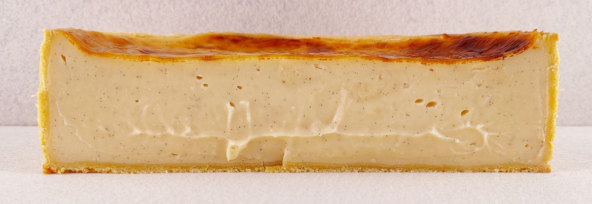 Primer plano de una porción rectangular de Tarta Ópera, destacando la textura lisa del glaseado de chocolate y la definición de las capas de bizcocho de almendra, crema de café y ganache de chocolate.