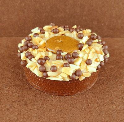 Porción individual rectangular de Tarta Ópera, fotografiada en ángulo de 45 grados con ligera inclinación, mostrando la cobertura de chocolate lisa y un grano de café decorativo en la parte superior.