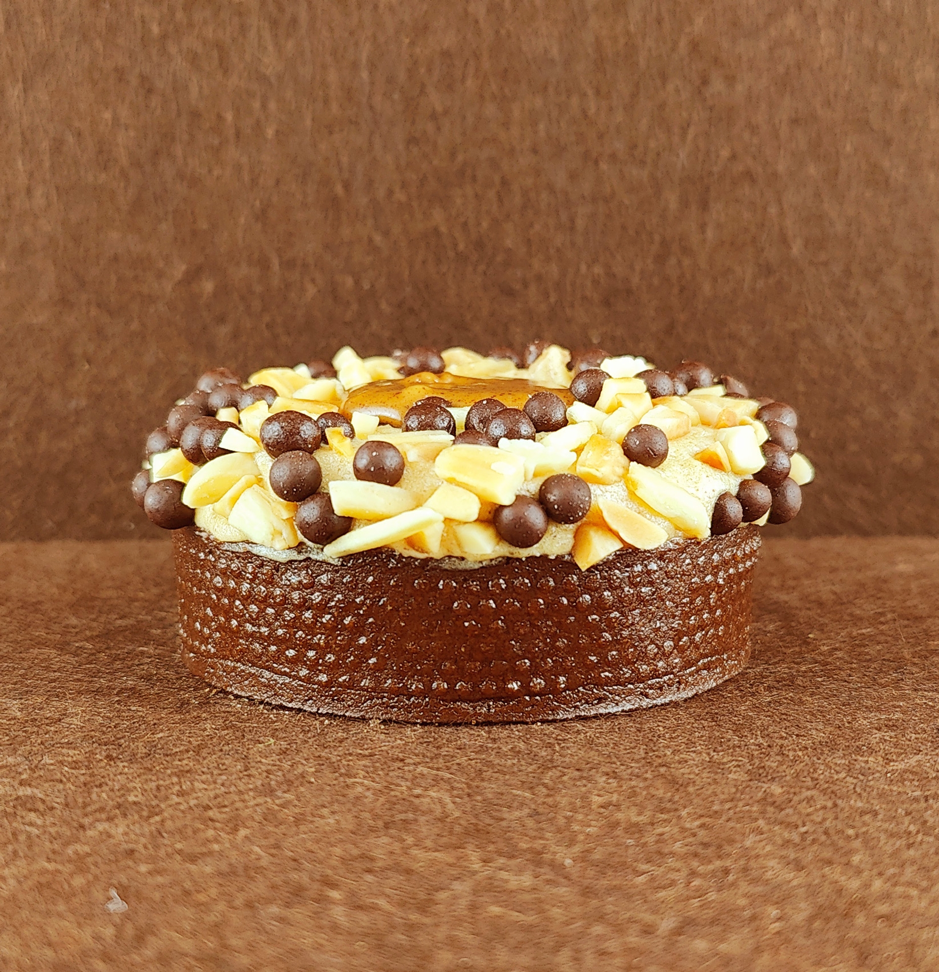 Primer plano de una porción rectangular de Tarta Ópera, destacando la textura lisa del glaseado de chocolate y la definición de las capas de bizcocho de almendra, crema de café y ganache de chocolate.